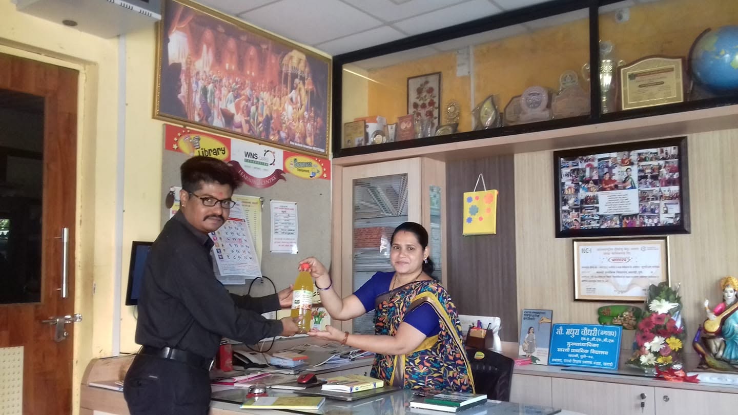 Orgasai team member handing an oil bottle to a customer